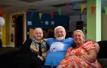 Three happy older people sitting together