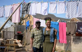 Older couple hanging washing outside on the line